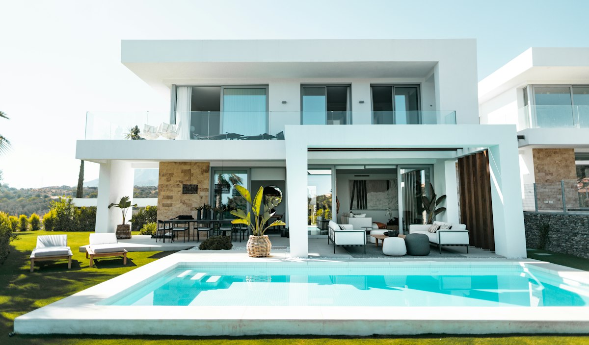 White luxury villa with a swimming pool and outdoor lounge